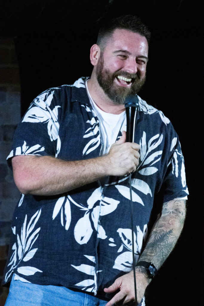 Chris Knight performing on stage at a Sydney comedy venue